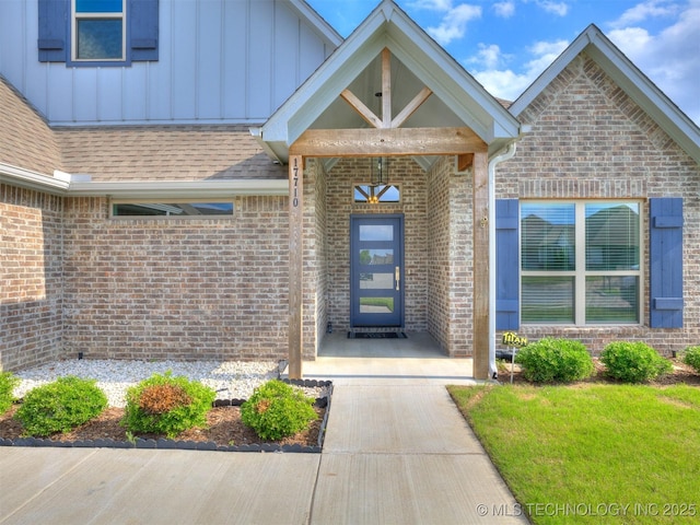 17710 E 45th Pl S, Tulsa, OK 74134 - doorway to property with board and batten siding, brick siding, and roof with shingles