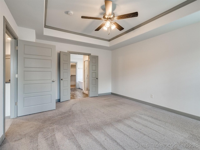 17710 E 45th Pl S, Tulsa, OK 74134 - unfurnished bedroom with a tray ceiling, carpet flooring, baseboards, connected bathroom, and ceiling fan