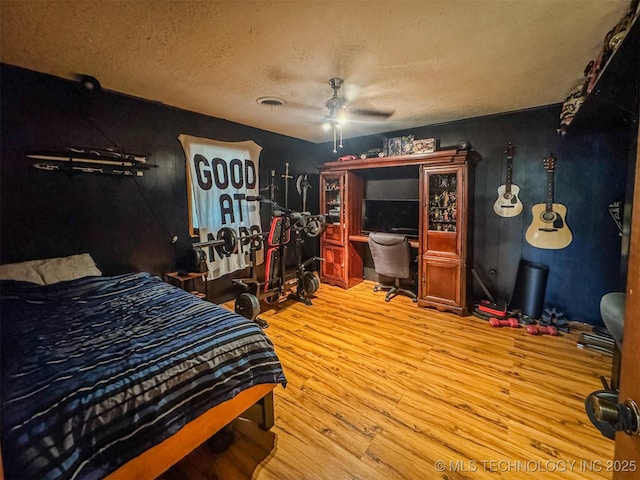 2064 Cave Creek Ct, Kansas, OK 74347 - bedroom featuring wood finished floors, a textured ceiling, a desk, and ceiling fan