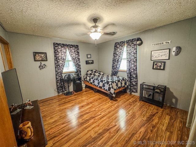 2064 Cave Creek Ct, Kansas, OK 74347 - bedroom with wood finished floors, a ceiling fan, and a textured ceiling