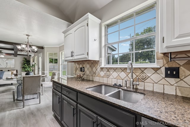 8602 S 91st E Ave, Tulsa, OK 74133 - kitchen featuring white cabinets, dark stone counters, a chandelier, decorative backsplash, and light wood-style floors