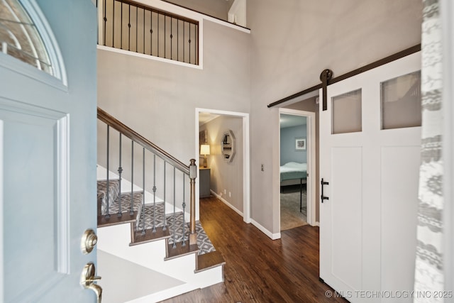 11029 E 66th St, Tulsa, OK 74133 - entrance foyer with dark wood-style flooring, a barn door, stairs, and a high ceiling
