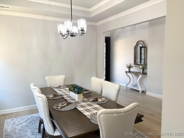 3816 E 117th Pl, Tulsa, OK 74137 - dining area with a chandelier, wood finished floors, ornamental molding, baseboards, and a raised ceiling