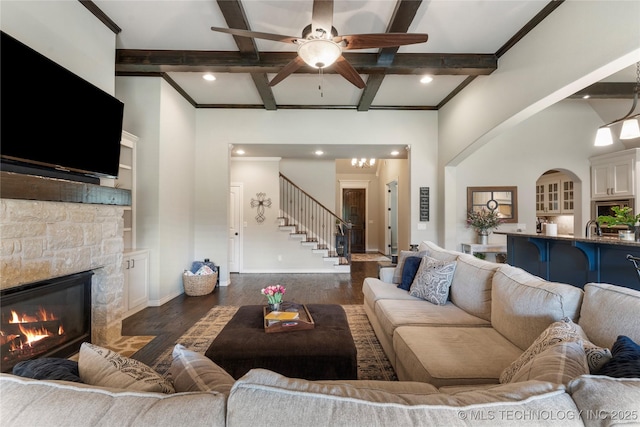 4472 S 169th E Ave, Tulsa, OK 74134 - living area with dark wood-style floors, stairway, a fireplace, beamed ceiling, and ceiling fan