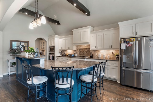 4472 S 169th E Ave, Tulsa, OK 74134 - kitchen with stainless steel appliances, arched walkways, white cabinets, backsplash, and a center island with sink