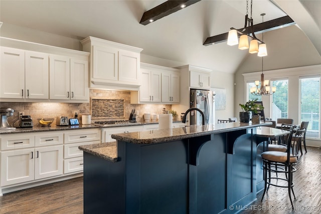 4472 S 169th E Ave, Tulsa, OK 74134 - kitchen featuring a kitchen breakfast bar, appliances with stainless steel finishes, dark wood finished floors, and white cabinetry