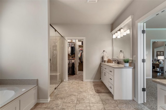 4472 S 169th E Ave, Tulsa, OK 74134 - full bathroom featuring vanity, a stall shower, a spacious closet, baseboards, and a tub