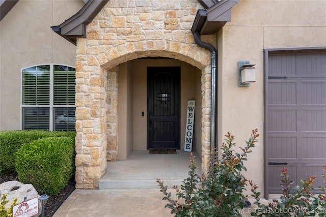 4472 S 169th E Ave, Tulsa, OK 74134 - doorway to property featuring stone siding, stucco siding, and a garage