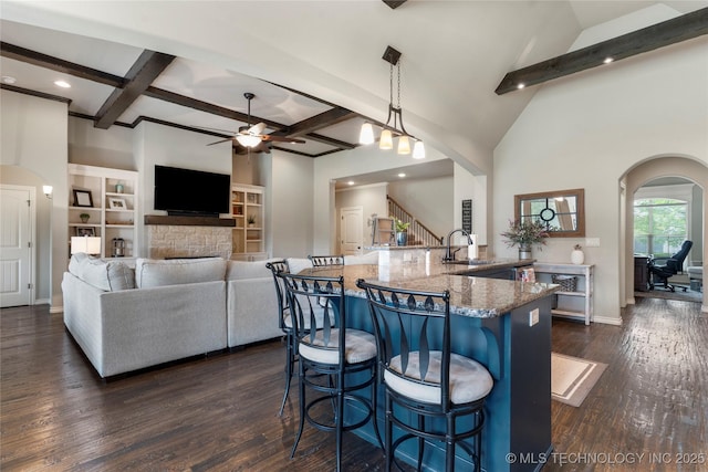 4472 S 169th E Ave, Tulsa, OK 74134 - kitchen with ceiling fan, stone counters, arched walkways, beamed ceiling, and a breakfast bar area