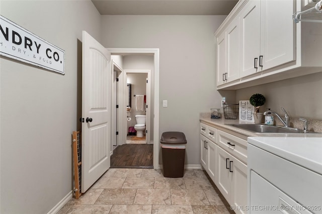 4472 S 169th E Ave, Tulsa, OK 74134 - washroom featuring baseboards, cabinet space, and light stone finish floors