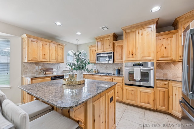 3012 W Mobile St, Broken Arrow, OK 74011 - kitchen featuring stainless steel appliances, light brown cabinets, a kitchen breakfast bar, decorative backsplash, and recessed lighting