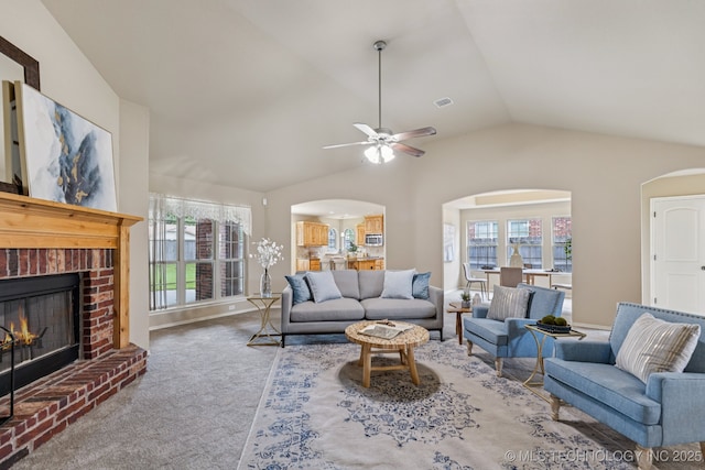 3012 W Mobile St, Broken Arrow, OK 74011 - living area with arched walkways, lofted ceiling, carpet, a ceiling fan, and a brick fireplace