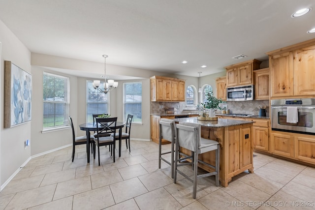 3012 W Mobile St, Broken Arrow, OK 74011 - kitchen with stainless steel appliances, backsplash, a center island, a chandelier, and recessed lighting