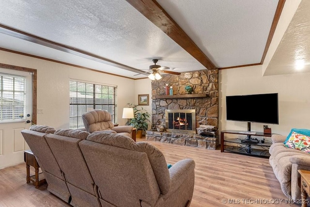 2612 W Quincy St, Broken Arrow, OK 74012 - living area with wood finished floors, a textured ceiling, ceiling fan, beam ceiling, and a stone fireplace