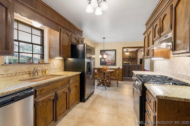 2612 W Quincy St, Broken Arrow, OK 74012 - kitchen with appliances with stainless steel finishes, a chandelier, under cabinet range hood, and a sink