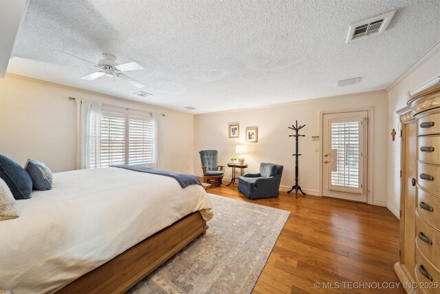 625 Grove Crest Rd, Pryor, OK 74361 - bedroom with multiple windows, a textured ceiling, wood finished floors, access to exterior, and ceiling fan
