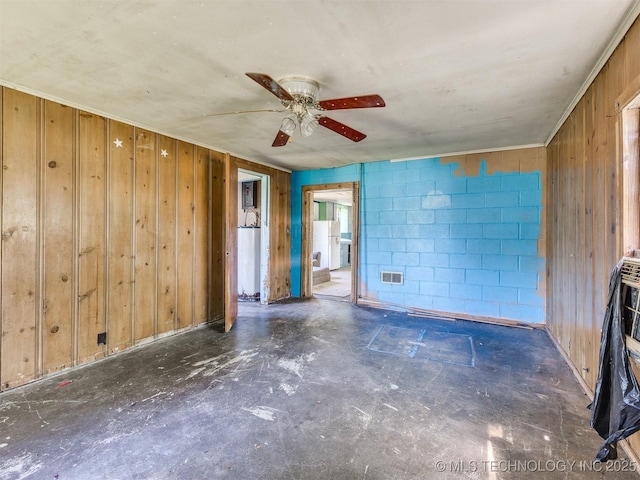 31229 E 682nd Rd, Wagoner, OK 74467 - spare room with wood walls, a ceiling fan, concrete block wall, and concrete floors