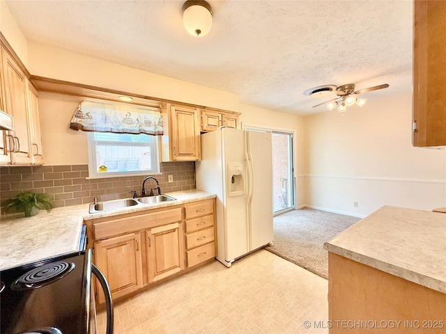 5641 S Newport Ave Unit 5641, Tulsa, OK 74105 - kitchen with light brown cabinetry, white refrigerator with ice dispenser, electric range, a sink, and a textured ceiling