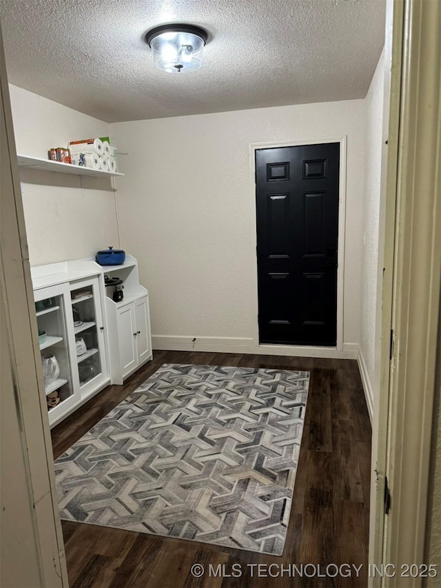 2752 Sawmill, Durant, OK 74701 - interior space featuring a textured ceiling, dark wood-style floors, and baseboards