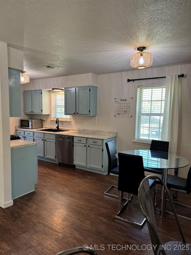 2752 Sawmill, Durant, OK 74701 - kitchen with appliances with stainless steel finishes, a sink, a textured ceiling, dark wood-style floors, and light countertops