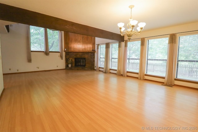 9337 S Lakewood Ave, Tulsa, OK 74137 - unfurnished living room featuring a chandelier, a stone fireplace, light wood finished floors, and plenty of natural light