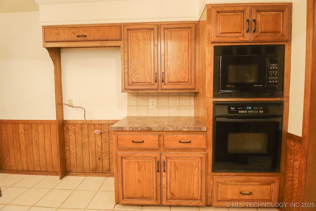 9337 S Lakewood Ave, Tulsa, OK 74137 - kitchen featuring black appliances, wainscoting, brown cabinetry, decorative backsplash, and light countertops