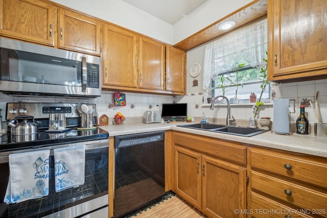 5614 S Newport Ave Unit 5614, Tulsa, OK 74105 - kitchen featuring stainless steel appliances, a sink, light countertops, and brown cabinetry