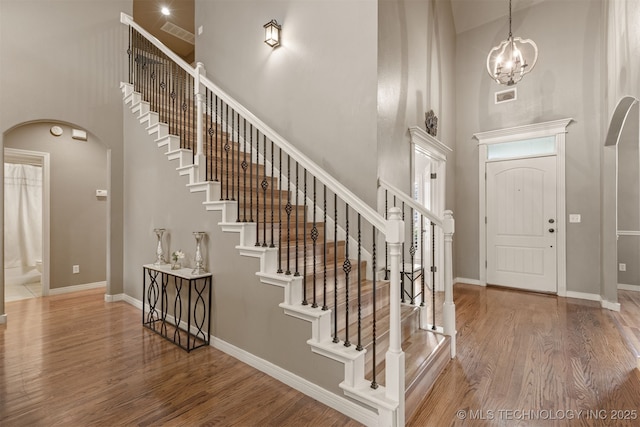 5006 S 164th E Ave, Tulsa, OK 74134 - foyer entrance with arched walkways, a high ceiling, wood finished floors, stairway, and a chandelier