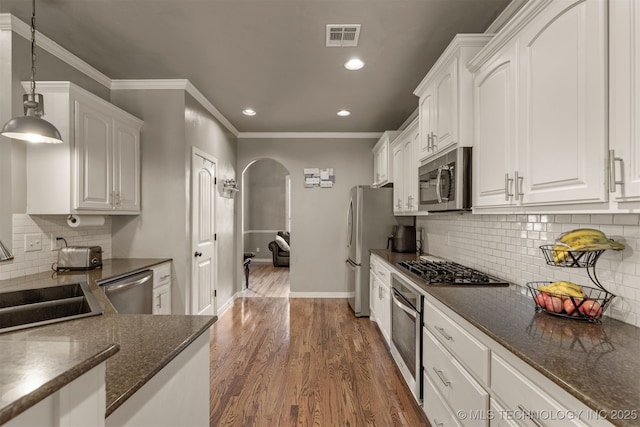 5006 S 164th E Ave, Tulsa, OK 74134 - kitchen with stainless steel appliances, arched walkways, white cabinets, a sink, and crown molding