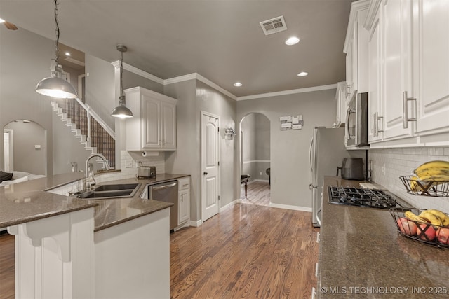 5006 S 164th E Ave, Tulsa, OK 74134 - kitchen featuring arched walkways, a sink, appliances with stainless steel finishes, white cabinetry, and recessed lighting