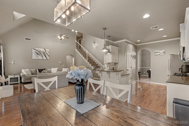 5006 S 164th E Ave, Tulsa, OK 74134 - dining room with arched walkways, stairs, light wood-style floors, recessed lighting, and baseboards