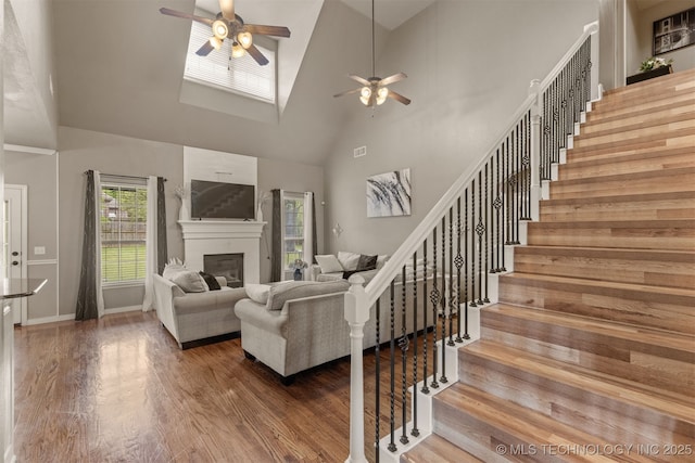 5006 S 164th E Ave, Tulsa, OK 74134 - living area with a ceiling fan, high vaulted ceiling, wood finished floors, stairs, and a glass covered fireplace