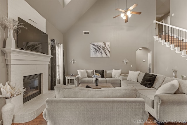 5006 S 164th E Ave, Tulsa, OK 74134 - living area featuring arched walkways, high vaulted ceiling, a ceiling fan, wood finished floors, and a glass covered fireplace