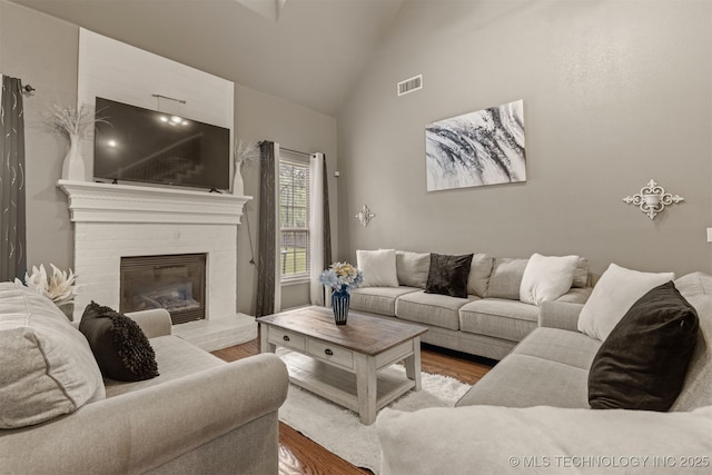 5006 S 164th E Ave, Tulsa, OK 74134 - living area with wood finished floors, high vaulted ceiling, and a brick fireplace