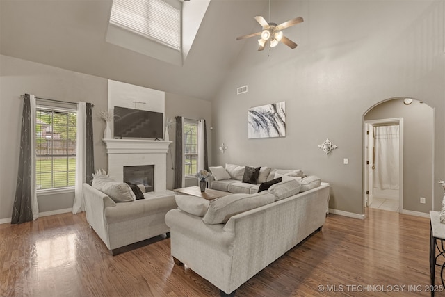 5006 S 164th E Ave, Tulsa, OK 74134 - living area with high vaulted ceiling, a ceiling fan, arched walkways, a brick fireplace, and baseboards
