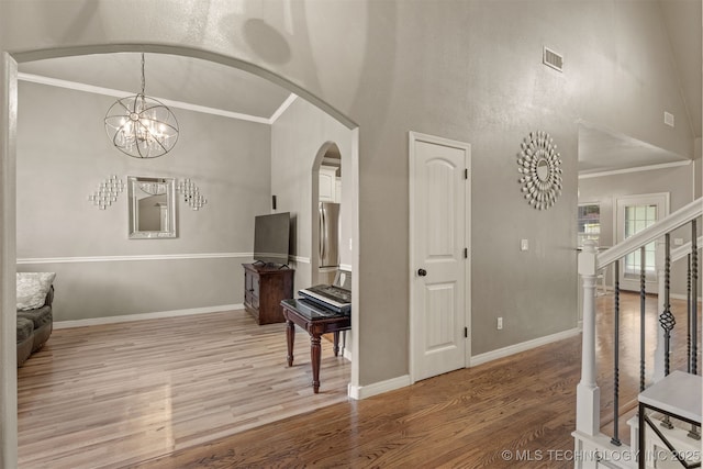 5006 S 164th E Ave, Tulsa, OK 74134 - living area featuring arched walkways, light wood-style flooring, crown molding, baseboards, and a high ceiling