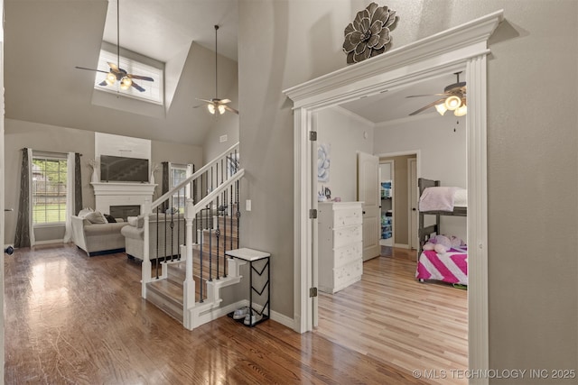 5006 S 164th E Ave, Tulsa, OK 74134 - entryway featuring a ceiling fan, stairs, wood finished floors, a high ceiling, and a glass covered fireplace