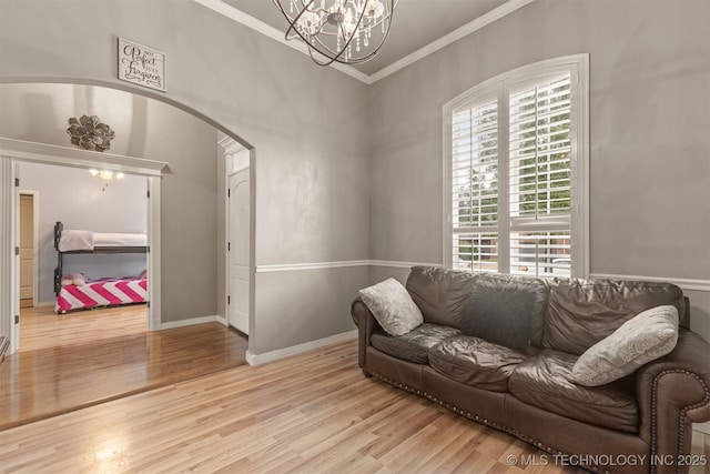 5006 S 164th E Ave, Tulsa, OK 74134 - living room featuring a chandelier, wood finished floors, ornamental molding, arched walkways, and baseboards