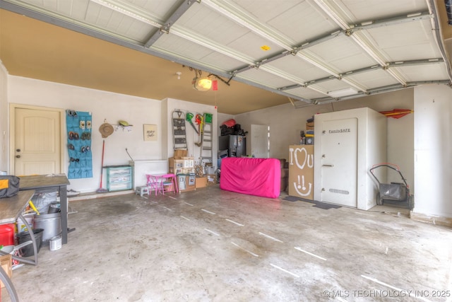 5006 S 164th E Ave, Tulsa, OK 74134 - garage featuring a garage door opener and stainless steel refrigerator with ice dispenser