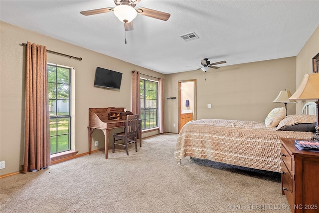 3419 State Highway 199, Dickson, OK 73401 - carpeted bedroom featuring multiple windows, ceiling fan, connected bathroom, and a textured ceiling