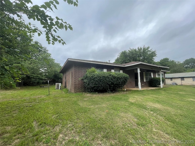 910 Race St, Boswell, OK 74727 - view of side of property featuring brick siding, a yard, and central AC