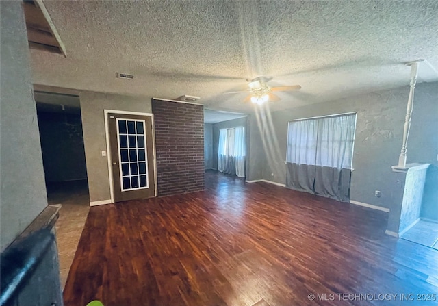 910 Race St, Boswell, OK 74727 - unfurnished living room with a ceiling fan, wood finished floors, a textured ceiling, and baseboards
