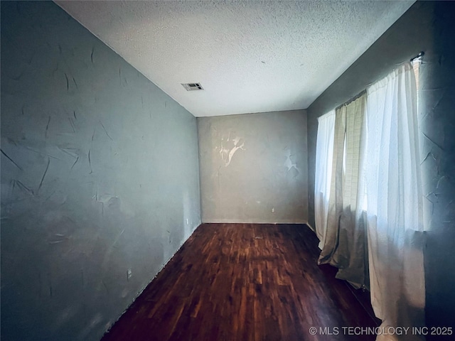 910 Race St, Boswell, OK 74727 - spare room with wood finished floors and a textured ceiling
