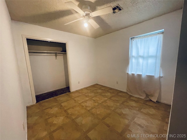 910 Race St, Boswell, OK 74727 - unfurnished bedroom with a textured ceiling, a closet, and a ceiling fan