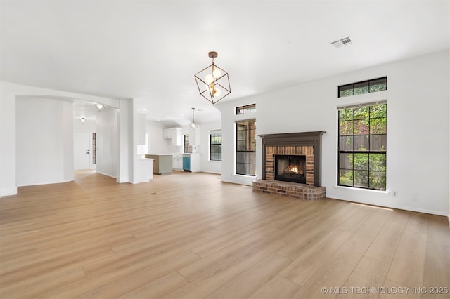 4204 W Freeport St, Broken Arrow, OK 74012 - unfurnished living room featuring plenty of natural light, light wood-type flooring, a fireplace, and a chandelier
