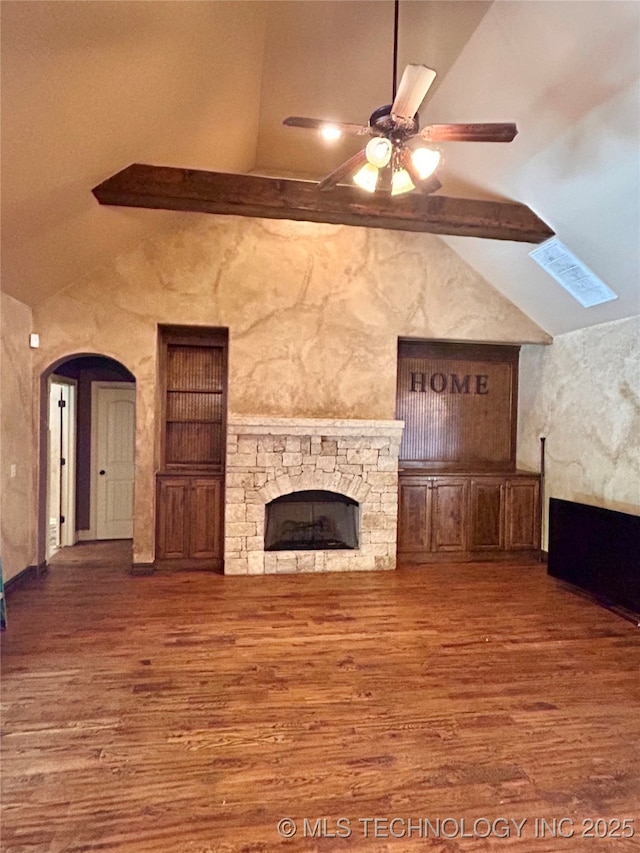 2508 E 140th Pl S, Jenks, OK 74008 - unfurnished living room featuring wood finished floors, a ceiling fan, a stone fireplace, and arched walkways