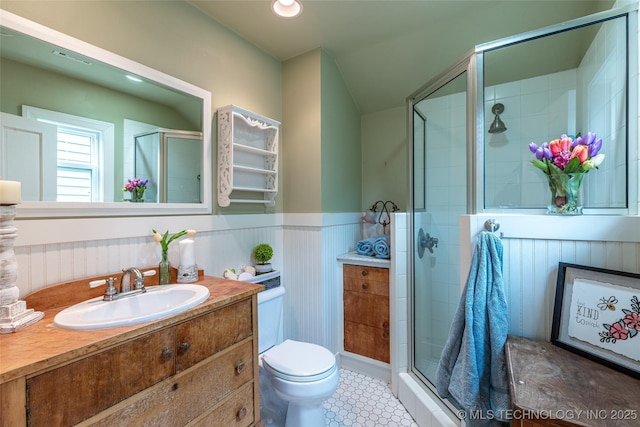 3160 S Owasso Ave, Tulsa, OK 74105 - bathroom with toilet, a stall shower, vanity, wainscoting, and tile patterned flooring