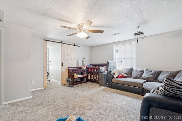 4316 S Ash Ave, Broken Arrow, OK 74011 - living room featuring ceiling fan, a barn door, carpet floors, a textured ceiling, and baseboards
