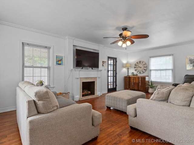 1629 Dewey Ave, Bartlesville, OK 74003 - living area featuring wood finished floors, ceiling fan, a fireplace with raised hearth, crown molding, and baseboards