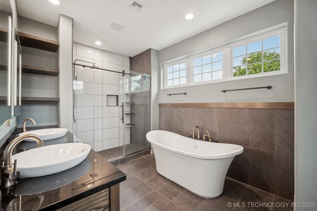 1611 S Lewis Pl, Tulsa, OK 74104 - full bathroom with a shower stall, tile walls, double vanity, a soaking tub, and tile patterned floors